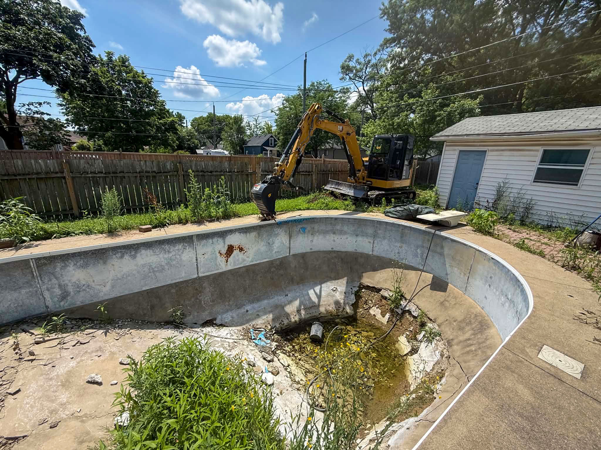 Empty inground pool before complete fill-in and removal