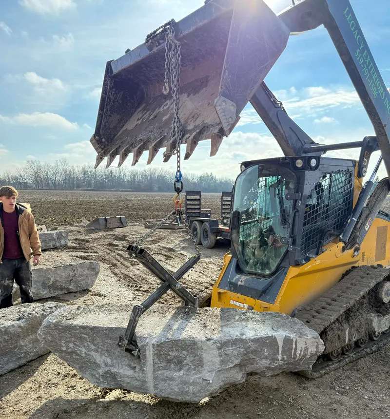 Heavy equipment lifting large boulder