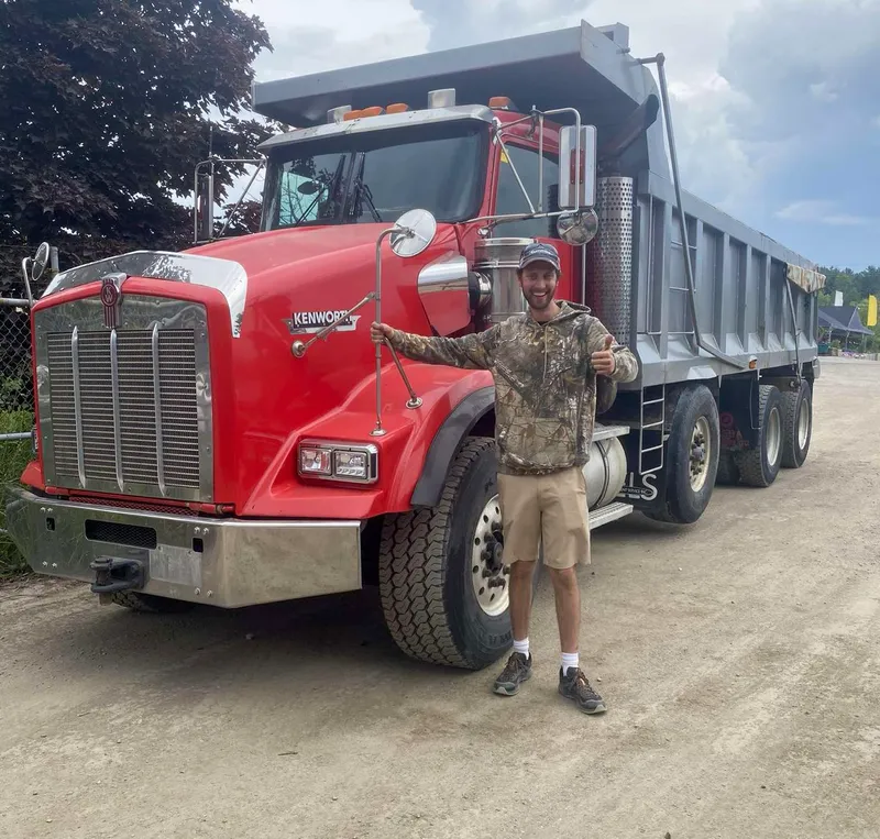 Team member posing with company truck